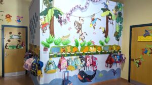 Οι τσάντες των νηπίων κρεμασμένες στον χρωματιστό τοίχο Παιδικού Σταθμού