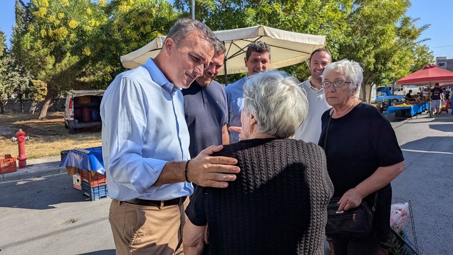 Ο Θ.Μαμάκος συνομιλεί με ηλικιωμένη κυρία σε δρόμο λαικής αγοράς.